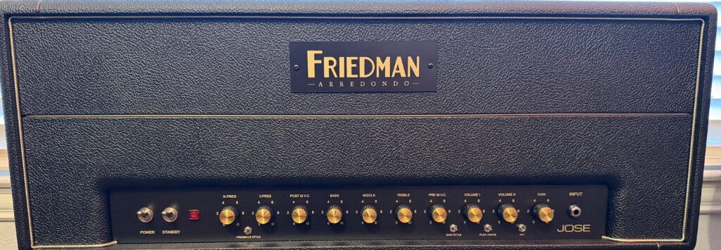 Friedman Arredondo Jose-style guitar amplifier head photographed indoors on a studio rack, showing its black enclosure, gold control knobs, and front panel switches.
