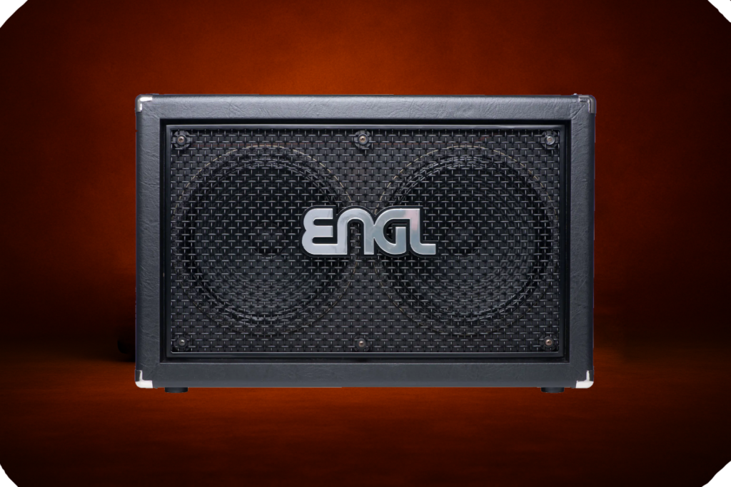 ENGL horizontal guitar speaker cabinet with metal grille, visible dual speakers, silver ENGL logo, and black enclosure, photographed on a dark orange studio background.