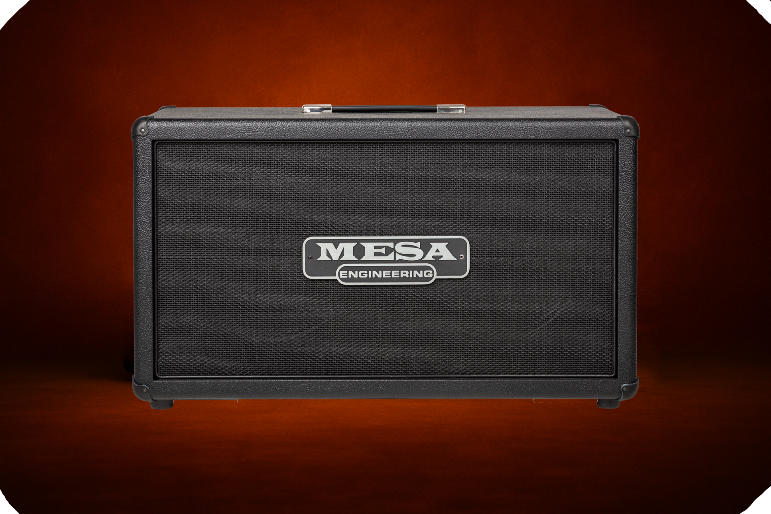 Mesa Engineering horizontal guitar speaker cabinet with black tolex, black grille cloth, silver Mesa Engineering badge, and top handle, studio-lit on a dark orange background.